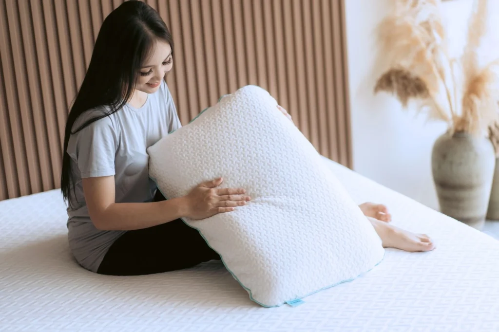 How to clean latex pillow - A woman's hand gently touching a Nosda Jumbo Pillow