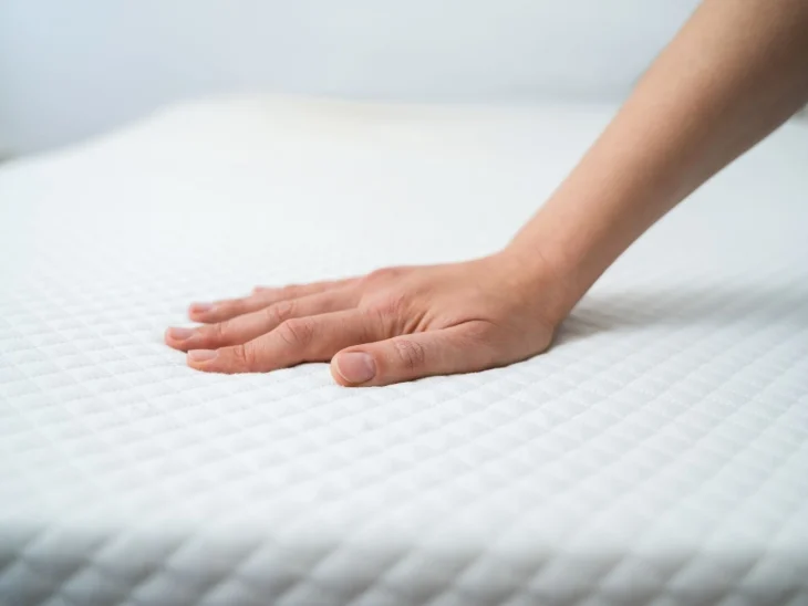 Natural Latex Mattress - A woman's hand pressing a mattress for firmness