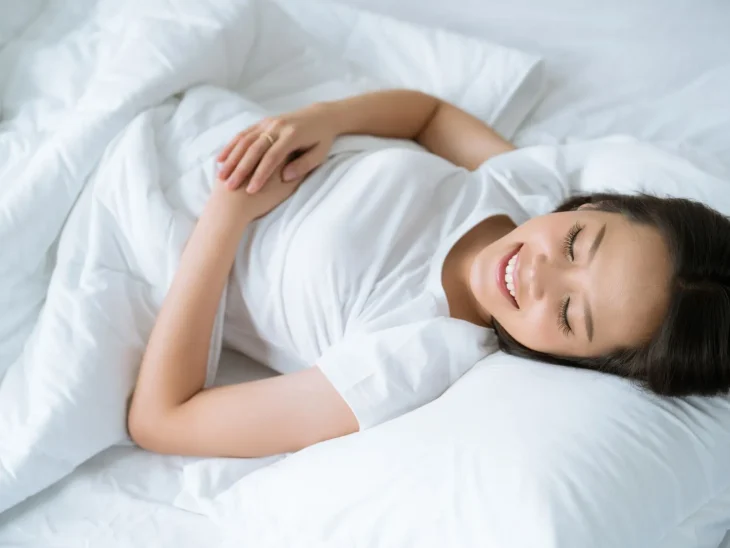 Woman sleeping happily on a bed